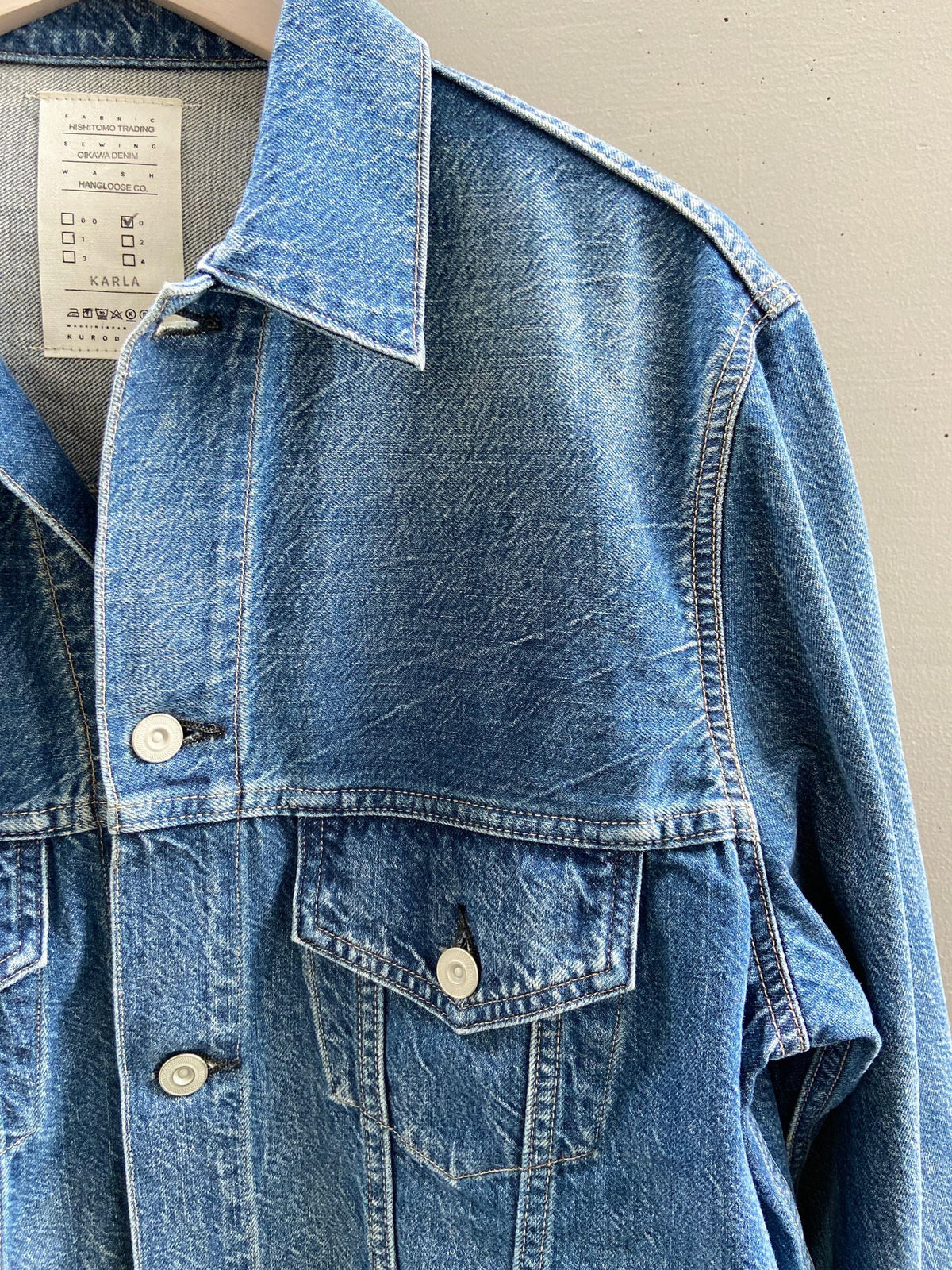 The chest of a kibata denim jacket, showing the twist from washing, the puckering along the seams and the wave in the fading
