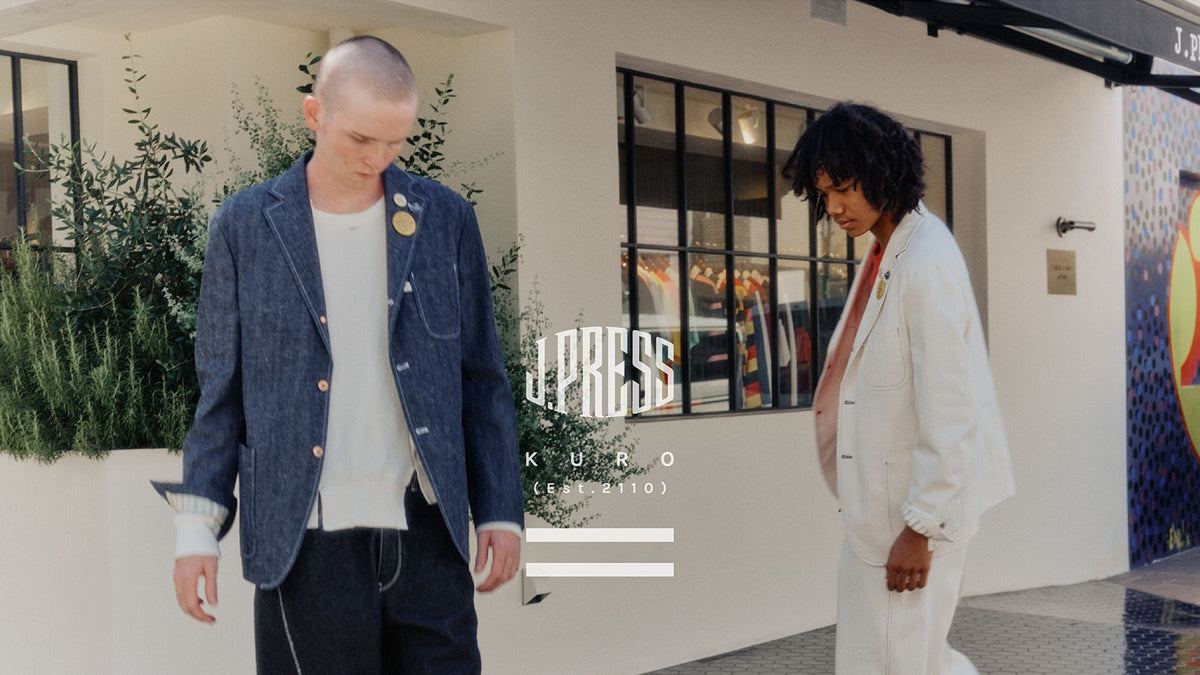 Two models outside the J.PRESS store, one in a denim jacket, one in off-white