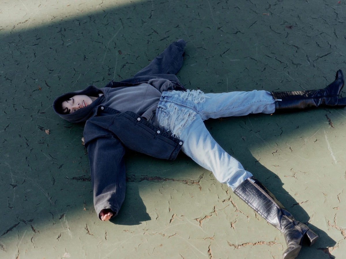 Full look with a black denim jacket, damaged denim and long boots
